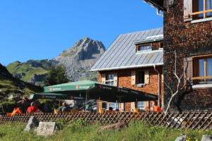 Blick auf die schöne Terrasse unserer Alpenvereinshütte, von der aus man beim Essen und Trinken die Aussicht auf die Umgebung genießen kann