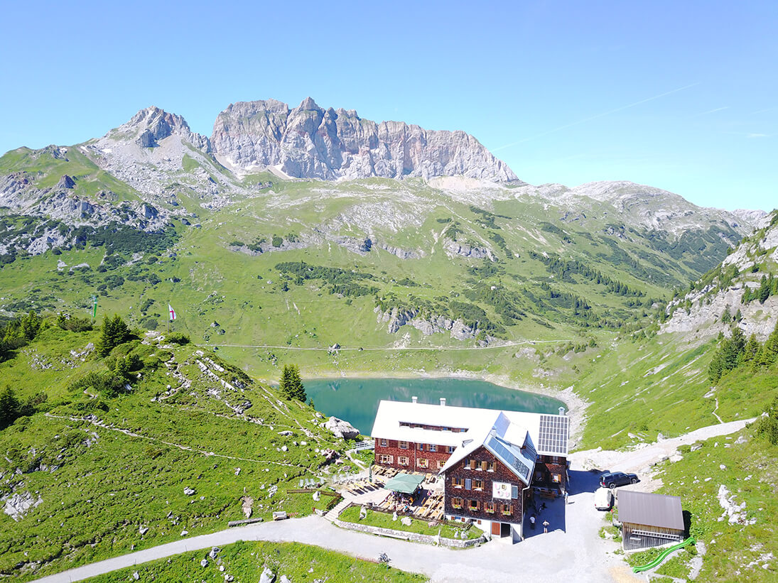 Blick auf die Freiburger Hütte, den Formarinsee und die Rote Wand