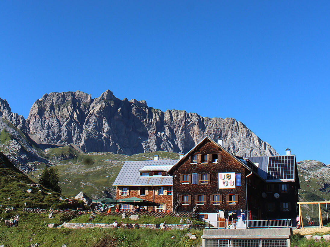 Die Freiburger Hütte in all ihrer Pracht bei strahlendem Sonnenschein und wolkenlosem Himmel